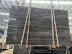 Front view of a Black Travertine slab bundle with dark layered movement