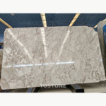 Pale Blossom Marble slab with interlocking white shapes and delicate beige and pink-toned veining