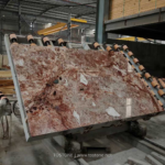 Blush Petals marble slab on a workshop handling table showing varied pink and cream areas