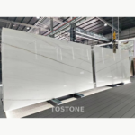Brazilian Calacatta White Quartzite slabs displayed side by side, with white backgrounds and long diagonal grey veins.