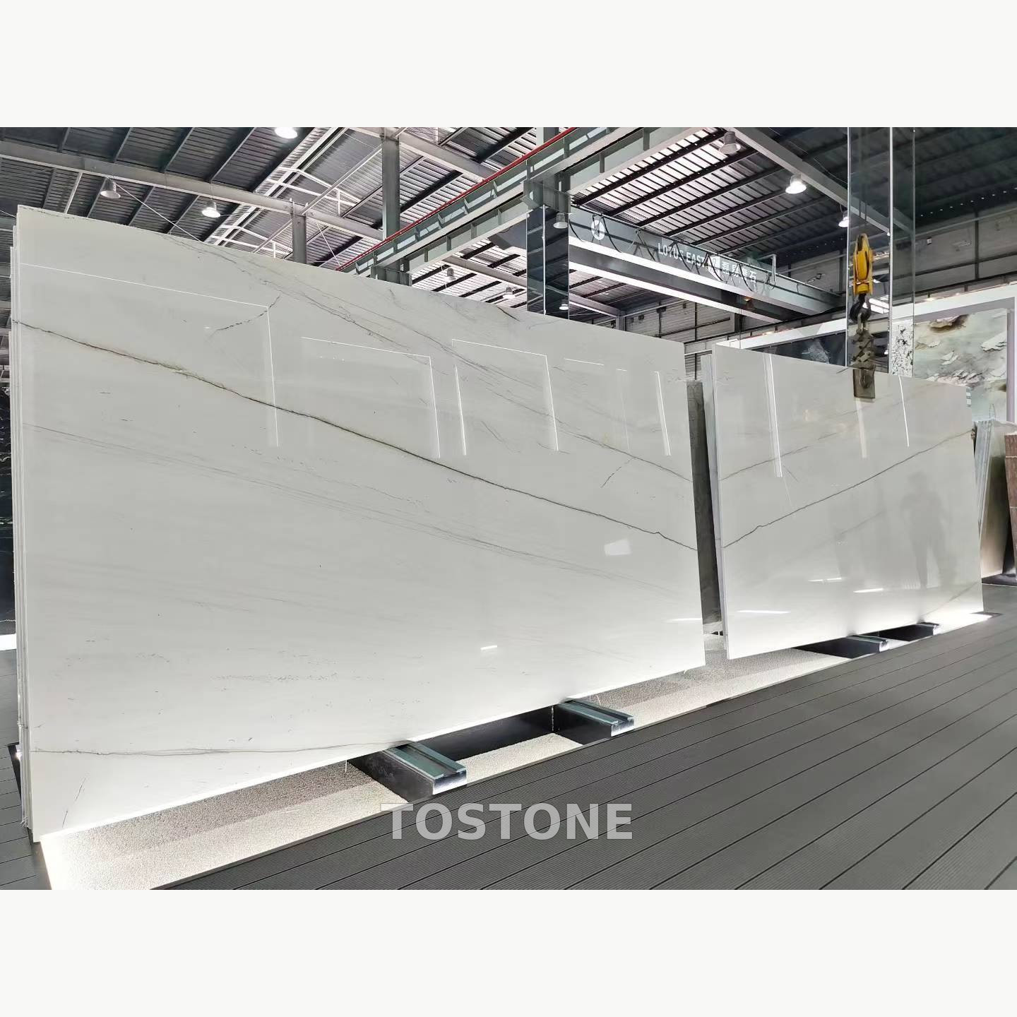 brazilian-calacatta-white-quartzite-01-square-review Brazilian Calacatta White Quartzite slabs displayed side by side, with white backgrounds and long diagonal grey veins.