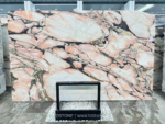 Calacatta Rosa marble slab showing large peach and cream areas with dark grey veins