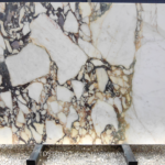 Front view of Italian Calacatta Viola marble slab with large ivory fields, deep plum-grey veins and gold accents