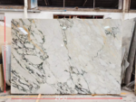 Calacatta Viola marble slab with broad ivory areas and dark branching veins concentrated along the left side