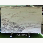 Desert Oasis Marble slab with a pale ivory field and sweeping grey veins concentrated along the lower edge