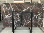 Espresso Vein marble slab displayed upright behind a handling frame