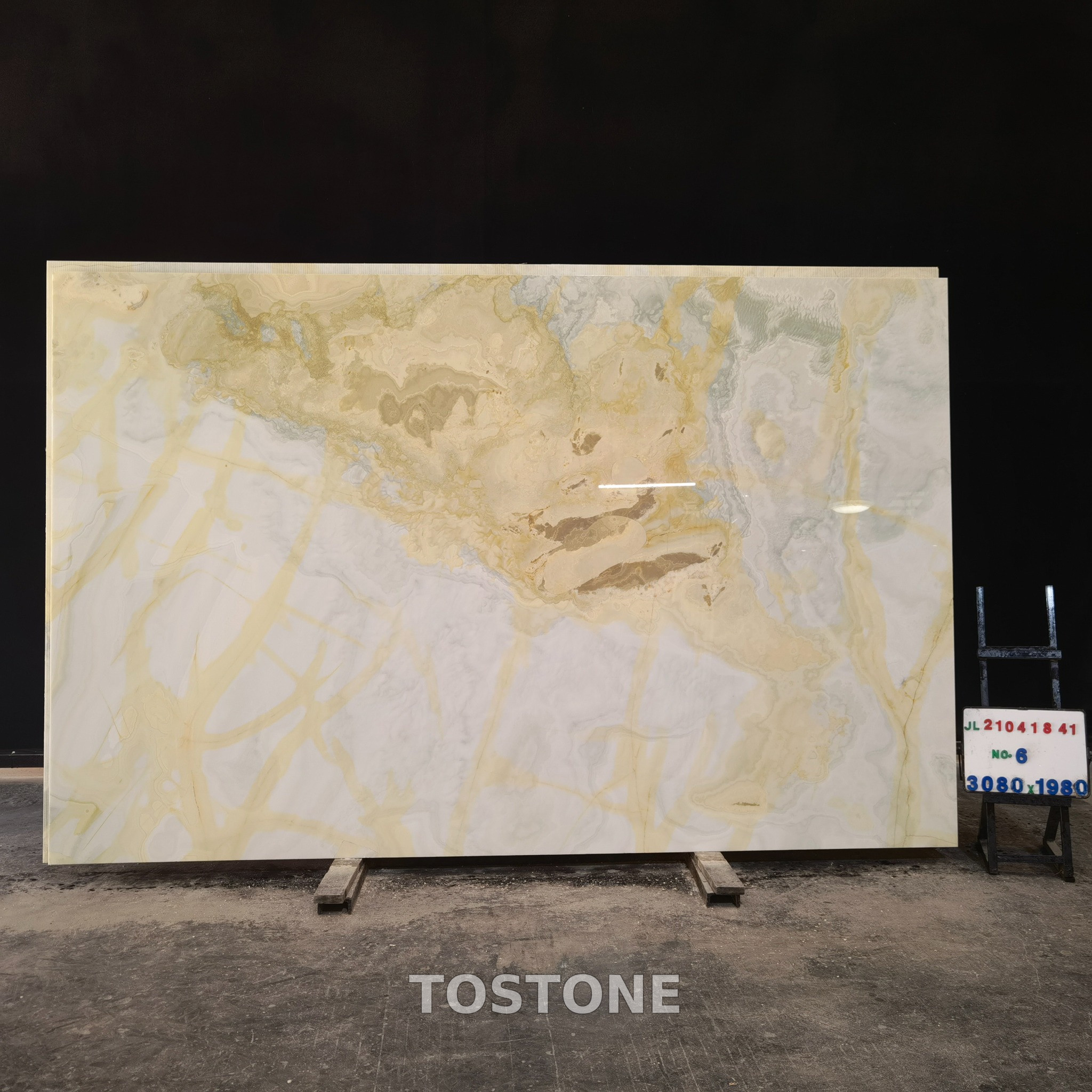 Golden Blue Jade Marble - TOSTONE Watermark 1 Golden Blue Jade Marble slab with a cream base, golden branching lines and pale blue-gray bands on the right.