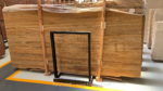Wide warehouse view of Golden Travertine slabs in a timber support frame