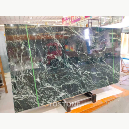 Greek Verde Alpi marble slab with a dark green background and branching white veins, held by green packing straps.