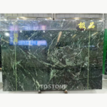 Greek Verde Alpi marble slab with swirling white and pale green veining and a display sign at the upper right.