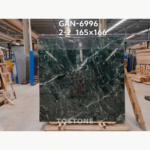 Front view of a Greek Verde Alpi marble slab with diagonal white bands and fine green-white veining.