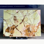 Gu Qing Yu stone slab with cream-green fields and broad amber-brown and pink-white markings