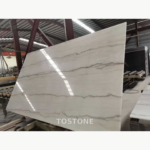 Guangxi White Marble slab on a factory processing line, showing long gray veins