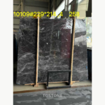 Hermes Grey Marble slab with a charcoal-grey base and dense silver-white veining on a timber support.