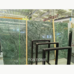 Indian Large Flower Green Marble slab bundle with dark branching veins, green straps and wooden supports