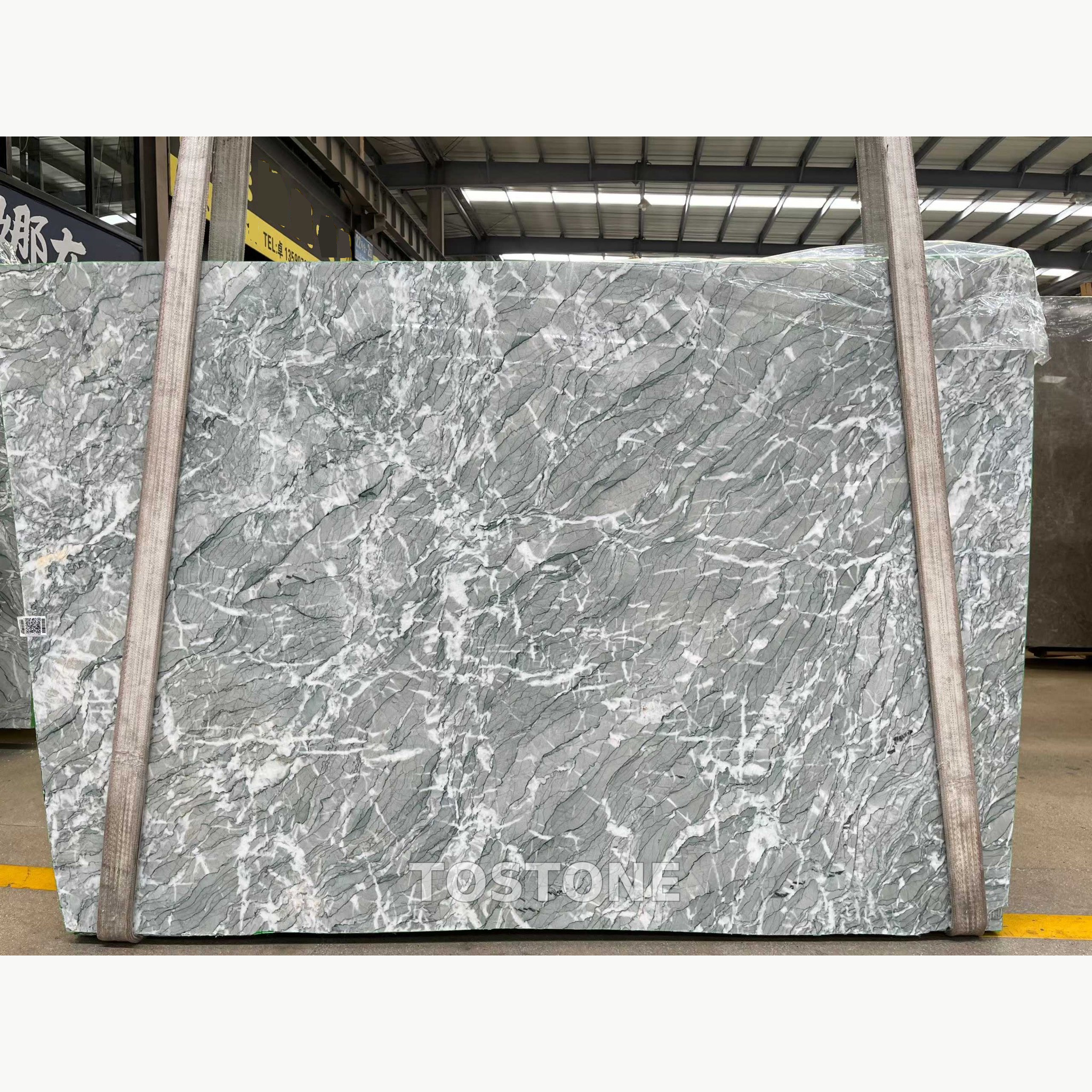 iranian-green-marble-slabs-01-partial-clean-square Iranian Green Marble slab with broad sage-grey areas, diagonal charcoal lines and crossing white veins