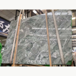 Angled view of Iranian Green Marble slabs with fine dark lines, white veins and lifting straps