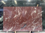 Kadiya Red Marble slab with a burgundy background, white branching veins and a dark gray accent