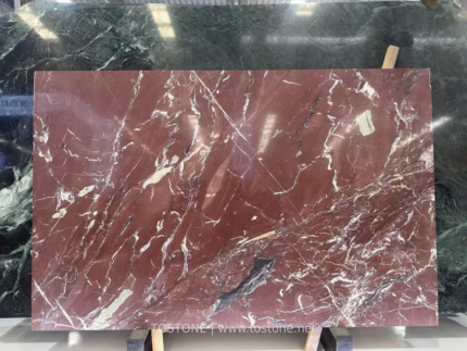Kadiya Red Marble slab with a burgundy background, white branching veins and a dark gray accent