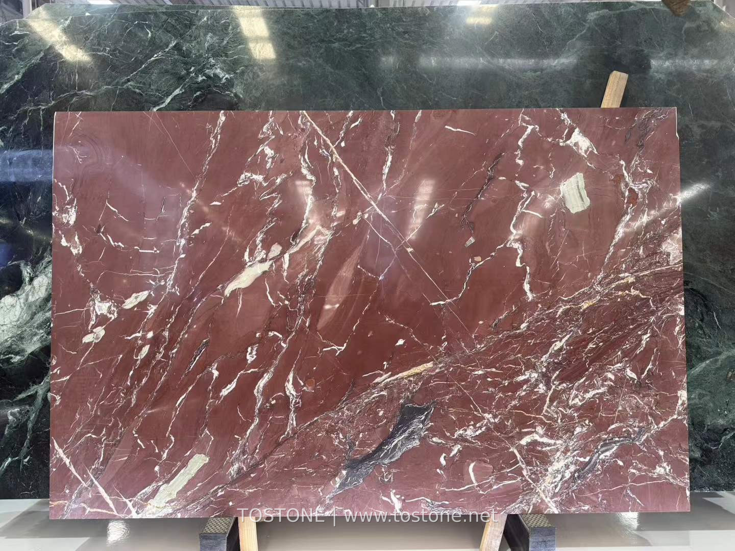 kadiya-red-marble-01-tostone-watermark Kadiya Red Marble slab with a burgundy background, white branching veins and a dark gray accent