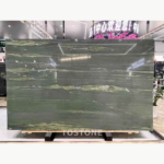 McLaren Green Marble slab in a showroom with deep olive-green colour and flowing pale green and white veins