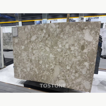 Montage Marble slab with irregular ivory and cream shapes across a taupe background in a showroom