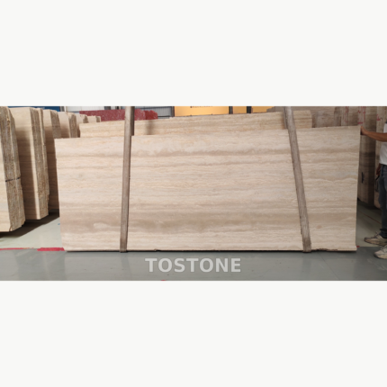 Front view of a Pakistan travertine slab with cream and beige horizontal bands, secured by two lifting straps.