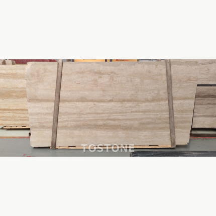 Pakistan travertine slab on timber supports, showing pale beige layers and a broad warm band across the centre.