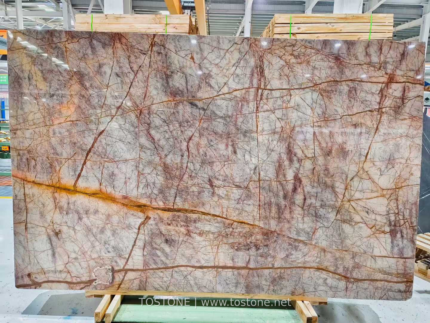 Phoenix Red Marble slab on timber supports showing red-brown veining and a sweeping golden band