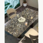Dining table design with a swirling dark Platinum Diamond stone top and cream chairs