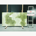 Qing Yu Marble slab with mottled olive-green fields and a broad pale cloud through the centre