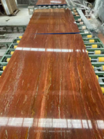 Red Travertine slabs on a production line showing linear golden veining