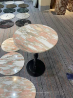 Design reference showing a round Rosa Norvegia marble tabletop beside circular stone samples
