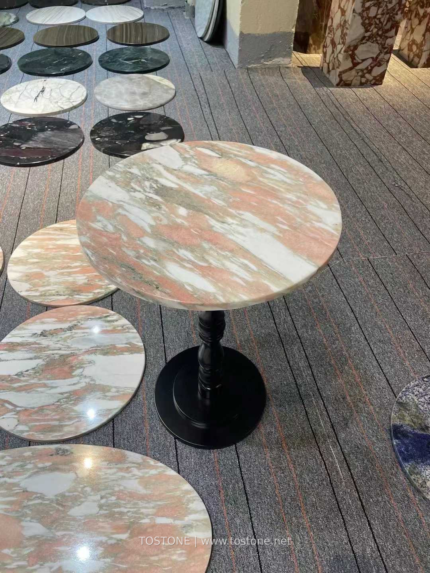 Design reference showing a round Rosa Norvegia marble tabletop beside circular stone samples