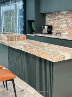 Design reference showing pink and cream patterned marble on a counter and backsplash with dark cabinetry