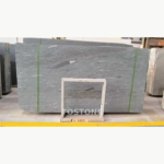 Sandalwood Snow Marble slab bundle with flowing grey-white details, green straps and a white support frame.