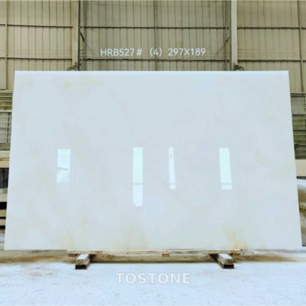 Full Snow White Marble slab on timber supports, with a pale white surface and subtle warm patches near the lower edge.