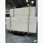 Snow White Marble slabs in a timber rack, showing soft ivory clouding and broad pale areas.