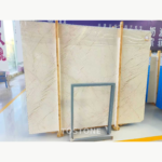 Sofitel Gold Marble slab with warm ivory shading and long diagonal brown veins rising across the surface.