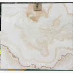 Straight Vein White Jade Marble slab with cloudy ivory-white shading, a warm beige area and scalloped brown edging near the bottom.
