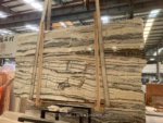 Tilamisu Travertine Slab supported upright with brown and charcoal horizontal bands