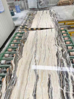 Tilamisu Travertine Slab on a roller conveyor showing long cream and charcoal lines