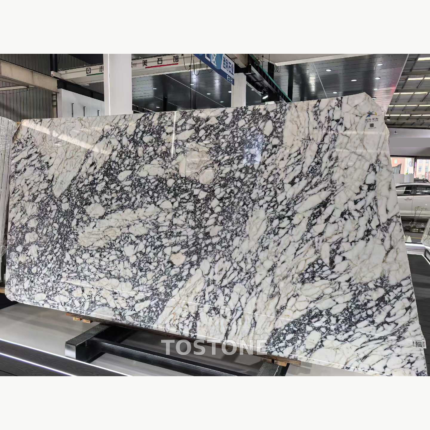 Turkish Calacatta Viola Marble slab with ivory-white fragments and dense dark grey veining in a showroom.
