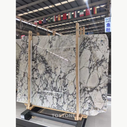 Turkish Calacatta Viola Marble slabs held in a wooden rack, showing broad pale areas and branching dark veins.