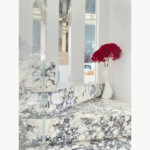 Interior detail of Turkish Calacatta Viola Marble across horizontal surfaces and vertical faces beside red flowers.
