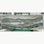Victoria Green Marble slab with horizontal gray-green waves and broad white bands, retaining the original green overlay.