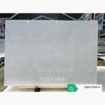 Vietnam Crystal White Marble slab in a showroom with subtle grey mottling and the numeric size annotation