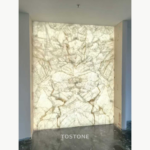 Illuminated White Crystal Marble feature wall with mirrored veining and pale cream, grey and gold tones.