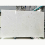 White Mushroom Marble slab with an ivory-white background and scattered gray and taupe markings.