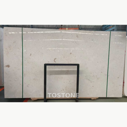 White Mushroom Marble slab bundle with pale cream clouding and small taupe fragments, secured by green straps.